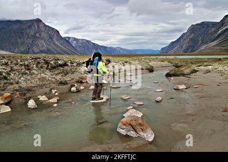 Trekking in der arktischen Tundra entlang des Owl River auf der Akshayuk Pass Traverse im Auyuittuq National Park, Baffin Island, kanadische Arktis Stockfoto