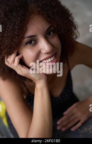 Entzückende junge Frau lächelt und sieht zufrieden aus Stockfoto