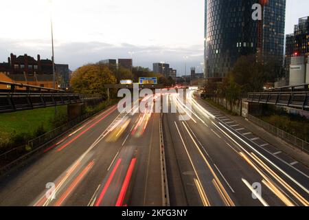 Mancunian Way Autobahnverkehr, Manchester durch die Unterführung des Stadtzentrums. Lange Belichtung mit Unschärfe der Fahrzeugbeleuchtung. M57 Ringstraße zur Hauptverkehrszeit. Stockfoto