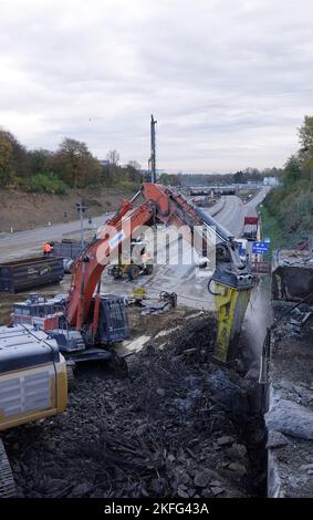 Hamburg, Deutschland. 18.. November 2022. Ein Bagger demoliert eine Brücke über die A7 in Hamburg. Die Autobahn nördlich und südlich des Elbtunnels wird von sechs auf acht Fahrspuren erweitert. Im Altona-Gebiet wird er mit einer gut zwei Kilometer langen Lärmschutzabdeckung versehen. Dafür sollen jetzt drei Brücken abgerissen werden. Quelle: Kilian Genius/dpa/Alamy Live News Stockfoto
