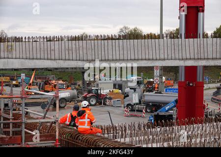 Hamburg, Deutschland. 18.. November 2022. Bauarbeiter und Baufahrzeuge sind auf der A7 in Hamburg zu sehen. Die Autobahn nördlich und südlich des Elbtunnels wird von sechs auf acht Fahrspuren erweitert. Im Altona-Gebiet wird er mit einer gut zwei Kilometer langen Lärmschutzabdeckung versehen. Dafür sollen jetzt drei Brücken abgerissen werden. Quelle: Kilian Genius/dpa/Alamy Live News Stockfoto
