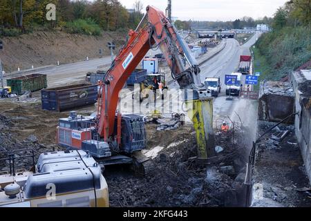 Hamburg, Deutschland. 18.. November 2022. Bagger reißen eine Brücke über die A7 in Hamburg ab. Die Autobahn nördlich und südlich des Elbtunnels wird von sechs auf acht Fahrspuren erweitert. Im Altona-Gebiet wird er mit einer gut zwei Kilometer langen Lärmschutzabdeckung versehen. Dafür sollen jetzt drei Brücken abgerissen werden. Quelle: Kilian Genius/dpa/Alamy Live News Stockfoto