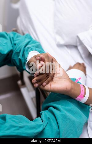 Ein Bild eines Arztes, der einen Patienten an der Hand hält. Stockfoto