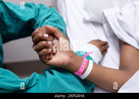 Ein Bild eines Arztes, der einen Patienten an der Hand hält. Stockfoto