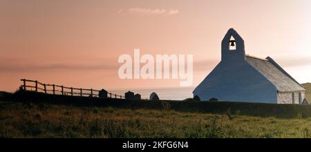 Blick auf die mittelalterliche Kirche des Heiligen Kreuzes am frühen Morgen im Sommer vom neuen Küstenpfad von Ceridigion aus gesehen, Mwnt Wales UK Stockfoto