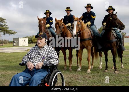 Pfc. (Ret.) James Hufnall posiert während seines 100. Geburtstags in Kerrville, Texas, vor berittenen Soldaten der 1. Kavallerie-Division, Horse Cavalry Detachment. Bei dieser Veranstaltung wurde Hufnall, der während des Zweiten Weltkriegs der 1. Brigade der 1. Kavallerie-Division zugeteilt wurde, mit dem Purple Heart ausgezeichnet. Geburtstag, Feier, Pferd, Troopers, VA, Zeremonie, Stockfoto