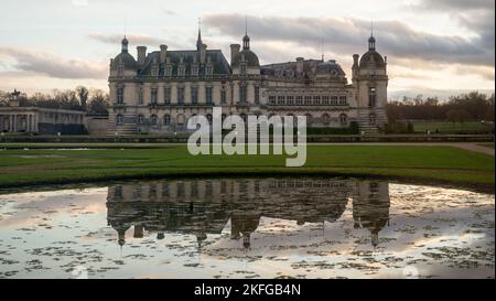 Domaine de Chantilly, Schloss Chantilly bei Sonnenuntergang, Schloss und Wolkenhimmel Spiegelung im Teich. Berühmtes Touristenziel in der Nähe von Paris. Stockfoto