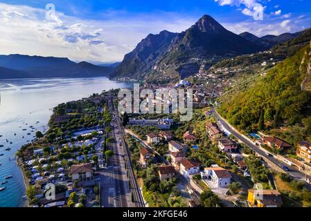 Malerische Berge und wunderschöne Seen Italiens - Luftdrohnenansicht des Iseo Sees und des Dorfes bei Sonnenuntergang. Provinz Brescia Stockfoto