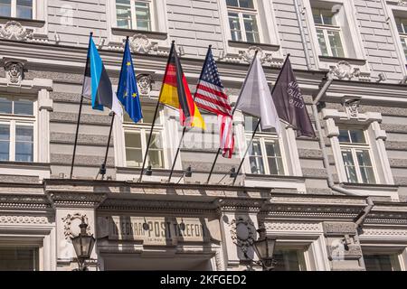 Estland, Tallinn - 21. Juli 2022: Nahaufnahme von 6 Flaggen über dem Eingang zum Hotel Telegraaf hellgraues Steingebäude im klassischen Stil in der Venes Street. Stockfoto