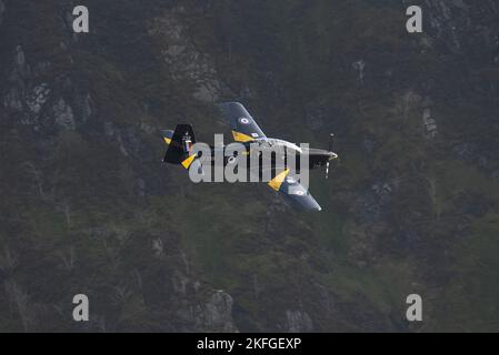 Aufgenommen am 1. November 2017 in der Mach Loop, Machynlleth, Wales, Großbritannien. Schwarz und gelb, RAF Training Kampfjet fliegt durch die Berge. Dunkelgrün Stockfoto