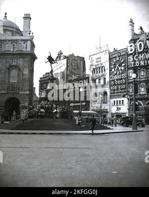 1949er Jahre, historisch, ein Blick aus dieser Ära des Piccadilly-Zirkus, Westminster, London, England, Großbritannien, mit Leuten am berühmten Shaftesbury Memorial Fountain. Im Volksmund als Eros bekannt, wurde der Brunnen mit seiner geflügelten Statue von Anteros 1892 errichtet, um der karitativen Arbeit des 7. Earl of Shaftesbury zu gedenken. Auf dem Bild sind auch einige der berühmten Werbetafeln zu sehen, die die Landschaft der Straßenkreuzung umgeben. Stockfoto