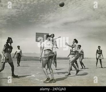 Afroamerikanische Frauen, Mitglieder der 32. und 33. Company's Women's Army Auxiliary Corps Basketballmannschaft, spielen eine Basketballspiel in Fort Huachuca, 1939 - 1945. Stockfoto