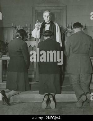 Ein Bischofsbischof bestätigt die afroamerikanischen Lieutenants Rosemary Vincent und Hallie M. Brown und einen nicht identifizierten Soldaten, während sie vor ihm knien, 1939 - 1945. Stockfoto