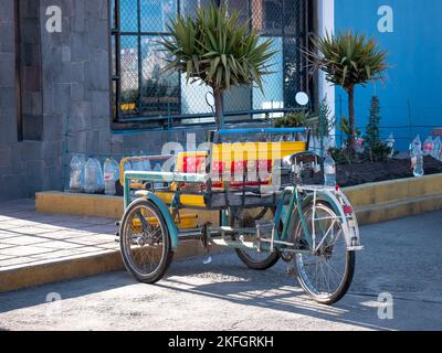 Puno, Peru - Juli 28 2022: Dreirad parkt auf der Straße mit einer Schubkarre davor, um schwere Dinge zu tragen und als Lieferer zu arbeiten Stockfoto