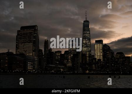 NEW YORK, NY, USA - 16. NOVEMBER 2022: Das One World Trade Center überragt in der Abenddämmerung die Skyline von Lower Manhattan. Stockfoto