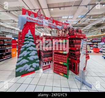 Cuneo, Italien - 18. November 2022: Ausstellungsstände mit Weihnachtsdekorationen, um vor Weihnachten Verpackungen von Flaschen und Dosen von Coca Cola auf Italienisch zu verkaufen Stockfoto