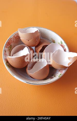 Eierschalen in einer weißen Schale auf dem Tisch Stockfoto