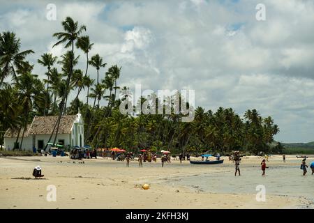 Praia dos Carneiros, Pernambuco, Brasilien - 09. November 2022 - kleine Kirche mit Blick auf den Strand mit Touristen. Stockfoto