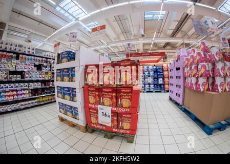 Cuneo, Italien - 18. November 2022: Paletten mit Weihnachtsgeschenkschachteln mit Balocco Panettone und Flaschen Sekt, Pandoro-Kuchen, ausgestellt in t Stockfoto