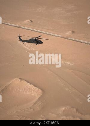 Ein UH-60m Black Hawk mit 3-142. Assault Helicopter Bataillon (AHB) aus Ronkonkoma, NY, errichtet einen Abstieg zur Landung in einer nicht verbesserten Landezone in der Nähe von Camp Buehring, Kuwait, 16. September 2022. Die Flugzeugbesatzungen für den 3-142. AHB führten einen Trainingsflug durch, um den Staub, die Trümmer und die allgemeine Sicherheit verschiedener Landezonen rund um das Camp Buehring zu bewerten. 3-142. AHB, der 36. Combat Aviation Brigade angeschlossen, unterstützt derzeit die kombinierte Joint Task Force - Operation Inhärent Resolve Mission, um gemeinsam vermittelte Kräfte bei der dauerhaften Niederlage von Da'esh zu beraten, zu unterstützen und zu ermöglichen, Stockfoto