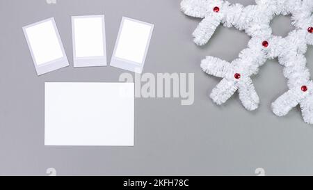 Polaroid retro Fotorahmen isoliert auf grauem Hintergrund. Vorlage für echte Fotos. Drei Bilder. Modell. Weihnachtliche weiße, flauschige Schneeflocke. Winter Stockfoto