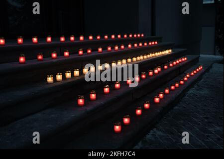 Rot-weiße brennende Kerzen auf Stufen, die die lettische Flagge symbolisieren. Der 18.. November ist die Feier des Unabhängigkeitstages in Lettland. Nahaufnahme. Stockfoto