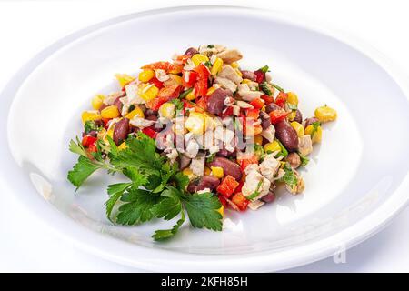 Hühnersalat mit Kirschtomaten, schwarzen Oliven, Nierenbohne, Mais, Gurken und Eissalat. Hausgemachtes Essen. Konzept für einen leckeren und gesunden m Stockfoto