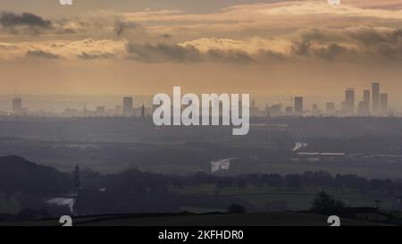 Die Silhouette der Manchester Skyline in der Ferne. Die Wolkenkratzer von Manchester steigen durch den Nebel. Dramatische stimmungsvolle Landschaft mit Blick über Manchester Stockfoto