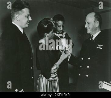 Mrs. Charles W. David, Jr.; afroamerikanische Witwe und ihr dreijähriger Sohn, Neil Adrian, erhalten die Navy and Marine Corps Medal vom Konteradmiral Stanley V. Parker, 1939 - 1945. Stockfoto