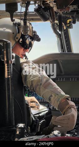 Chief Warrant Officer 2 James Marchetti, ein Troy, NY, gebürtiger Und UH-60m Black Hawk Pilot for A Company, 3 16-142. 2022 Assault Helicopter Bataillon (AHB) mit Sitz in Latham, New York, stellt während eines Trainingsfluges in der Nähe von Camp Buehring, Kuwait, den Schalter an der Mittelkonsole eines UH-60m Black Hawk ein. Marchetti und seine Crew haben während ihres Fluges Landezonen in der Nähe des Camp Buehring untersucht. 3-142. AHB, der 36. Combat Aviation Brigade angeschlossen, unterstützt derzeit die kombinierte Joint Task Force - Operation Inhärent Resolve Mission, um zu beraten, zu unterstützen und zu ermöglichen Teil Stockfoto