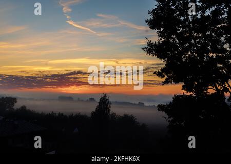 Panoramablick auf die bunte Dämmerung über dem Fluss mit Nebel am frühen Sommermorgen. Hochwertiges FotoPanoramablick auf die farbenfrohe Dämmerung über dem Fluss mit Nebel am frühen Sommermorgen. Stockfoto