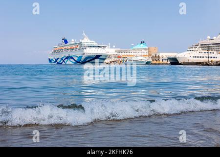 Rhodos, Griechenland - 23. August 2022: Panoramablick auf schöne Yachten, touristische Fähren stehen im Hafen von Rhodos, Griechenland. Stockfoto