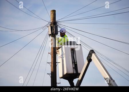 BT openreach-Ingenieur, der an Telefonkabeln von einem Cherry Picker arbeitet Stockfoto