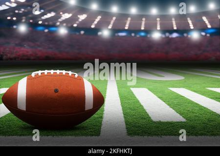 American Football auf dem Feld im Stadion mit dramatischer Punktbeleuchtung und Kopierfläche. Konzentrieren Sie sich auf den Vordergrundball mit geringer Schärfentiefe im Hintergrund. Stockfoto