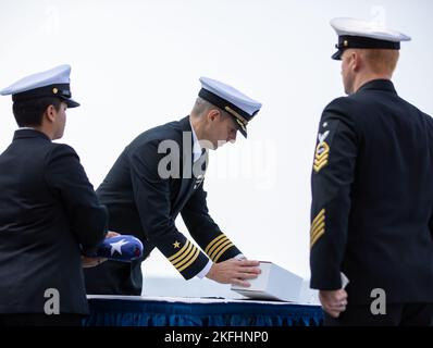 220917-N-PL946-1263 ATLANTISCHER OZEAN (SEPT 17, 2022) Capt. Derek Fix, Stabschef der Carrier Strike Group 12 (CSG 12), lässt die eingeäscherten Überreste eines Familienmitglieds während einer Beerdigung auf See an Bord des erstklassigen Flugzeugträgers USS Gerald R. Ford (CVN 78) frei. Während der Zeremonie wurden die eingeäscherten Überreste von 30 Seelen ins Meer im Atlantischen Ozean gebracht. Ford führt derzeit im Atlantischen Ozean Qualifizierungen von Fluggesellschaften durch und arbeitet für einen geplanten Einsatz im Herbst. Stockfoto