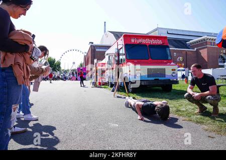 Ein Teilnehmer der jährlichen Big E führt Liegestütze für die U.S. Marines of Recruiting Station Springfield in West Springfield, Massachusetts, am 17. September 2022 durch. Das jährliche Festival begrüßt Menschen aus dem ganzen Staat, um die zahlreichen Tierausstellungen, kommerziellen Attraktionen, Festivalfahrten, Essen und Unterhaltung zu erleben. Stockfoto