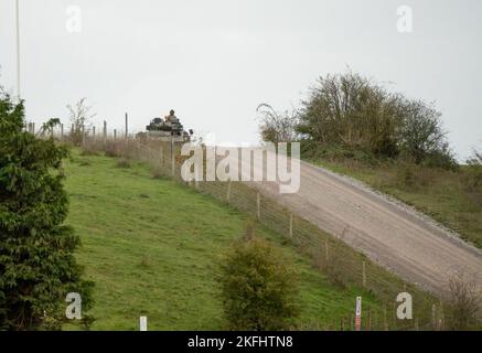 Britische Armee Warrior FV510 Kampffahrzeug in Aktion Fahren auf einer Schlammspur bei einer militärischen Kampfübung, Wiltshire UK Stockfoto