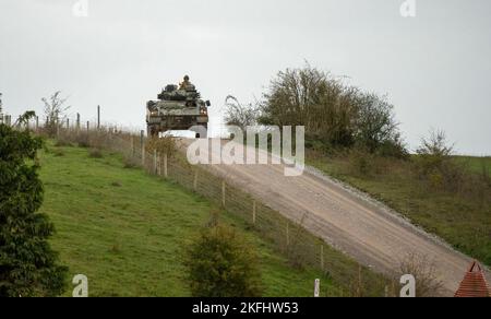 Britische Armee Warrior FV510 Kampffahrzeug in Aktion Fahren auf einer Schlammspur bei einer militärischen Kampfübung, Wiltshire UK Stockfoto