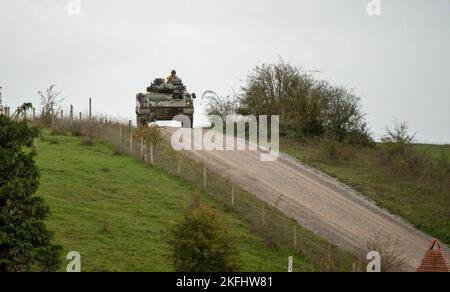 Britische Armee Warrior FV510 Kampffahrzeug in Aktion Fahren auf einer Schlammspur bei einer militärischen Kampfübung, Wiltshire UK Stockfoto