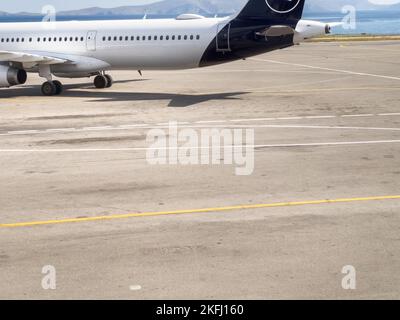 Zugeschnittenes Bild von der Landung des Flugzeugs auf der Start- und Landebahn des Flughafens während eines sonnigen Tages Stockfoto