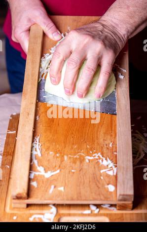 Bereiten Sie den Kohl für die Gärung vor. Schneiden von Kohl auf dem Schneideplotter. Hausgemachtes Sauerkraut. Stockfoto