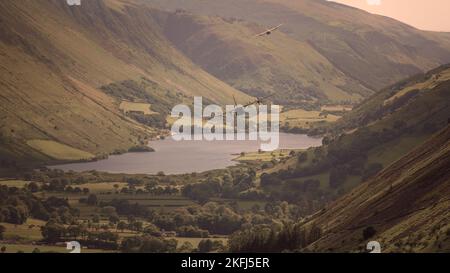 Zwei militärische Transportflugzeuge, die im Niedrigflugsystem des Vereinigten Königreichs durch den Mach-Loop, Machynlleth, Wales, Vereinigtes Königreich, fliegen. Stockfoto