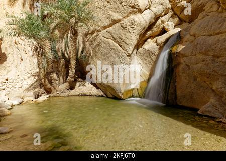 Langzeitbelichtung der Oase Chebika in Tunesien. Reiseziel. Urlaub und Entspannung in der Wüste. Wasserfall in einem wasserunruhigen und sandigen Gebiet. Stockfoto