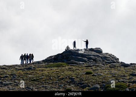 Touristen, die Fotos und Selfies auf dem Gipfel der Serra da Estrela, dem höchsten Berg des kontinentalen Portugals, machen. Menschen auf dem Gipfel des Berges. Stockfoto