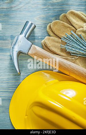 Zusammensetzung von Schutzhandschuhen Klauenhammer Nägel Bau Helm auf Holzbrett Konstruktionskonzept. Stockfoto