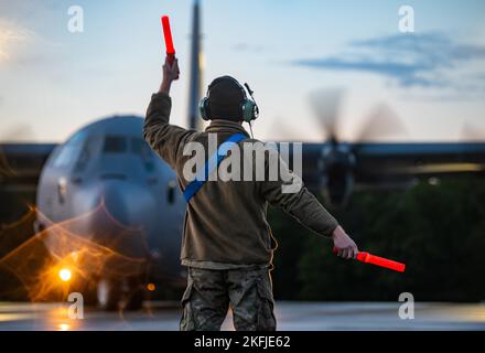 US Air Force Airman 1. Class Matthew Sanders, 86. Aircraft Maintenance Squadron Aerospace Propulsion Geselle, Marshalls a C-130J Super Hercules Aircraft, assigned to the 37. Airlift Squadron, before take-off for a night sortie during Aviation Detachment Rotation 22-4 Training at the 33. Air Base, Powdiz, Poland, September 19, 2022. Die Teilnahme an ADR 22-4 verbesserte unsere beruflichen Beziehungen und verbesserte die Interoperabilität mit Verbündeten und Partnermilitärs. Stockfoto