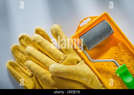 Schutzhandschuhe aus Leder lackieren Tray Roller auf weißer Oberfläche. Stockfoto