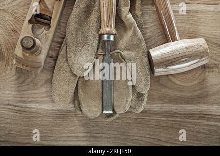 Schutzhandschuhe für Meißel auf Holzbrett. Stockfoto