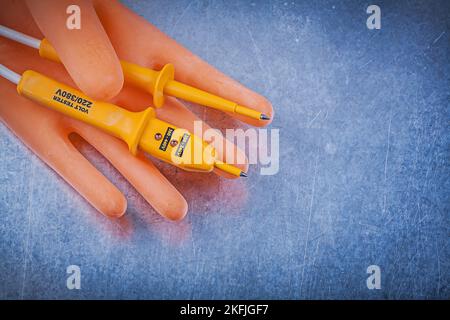 Satz von Isolierhandschuhen elektrische Tester auf metallischem Hintergrund elektrische Konzept. Stockfoto