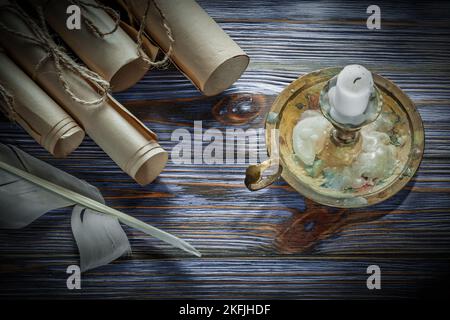 Vintage Papierrollen Plume Candlestick Kerze auf blauem Holzbrett. Stockfoto